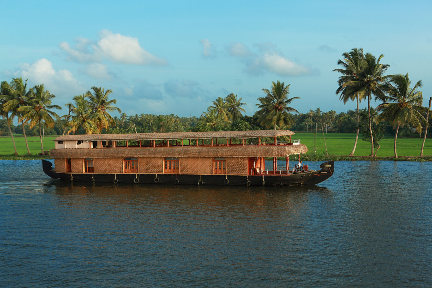 Traditional thatched luxury houseboat cruising through serene Alleppey backwaters